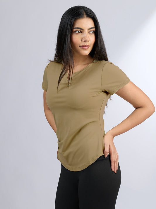 Woman wearing a beige t-shirt and black pants on a white background