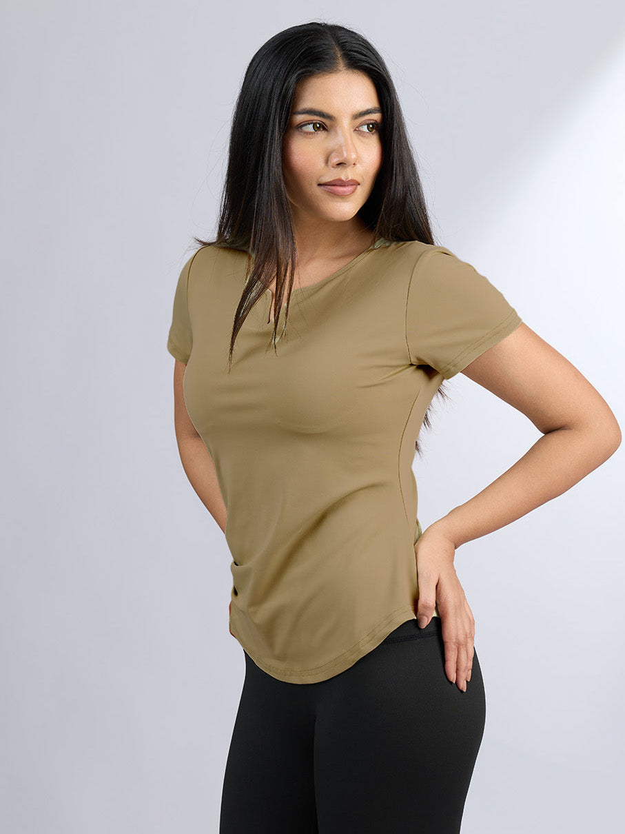 Woman wearing a beige t-shirt and black pants on a white background