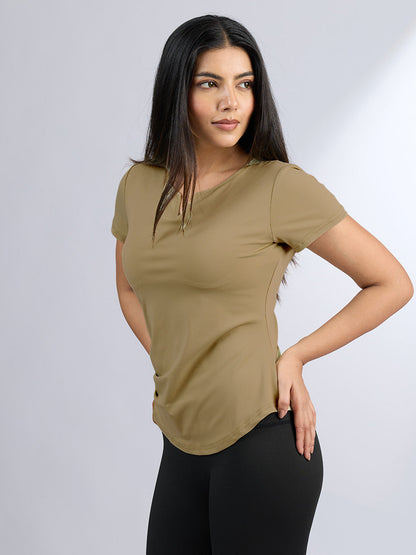 Woman wearing a beige t-shirt and black pants on a white background